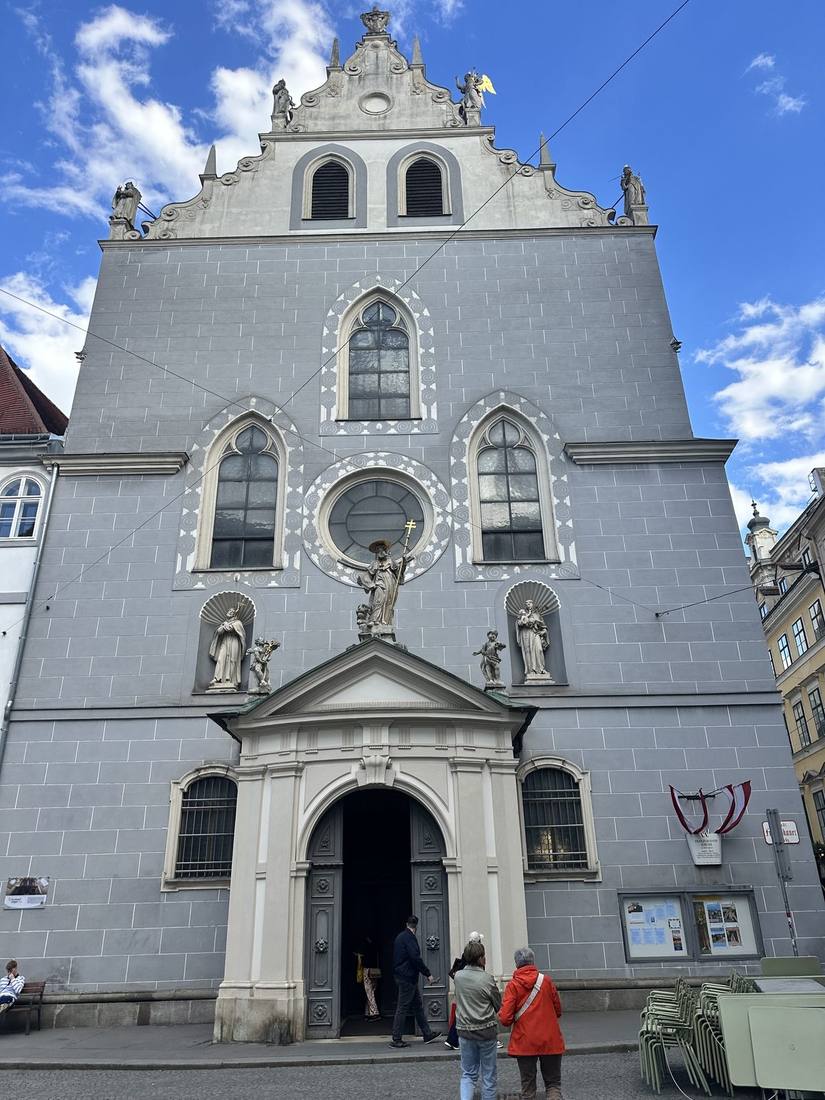 Grey façade of Franziskanerkirche with Gothic windows and Renaissance gable