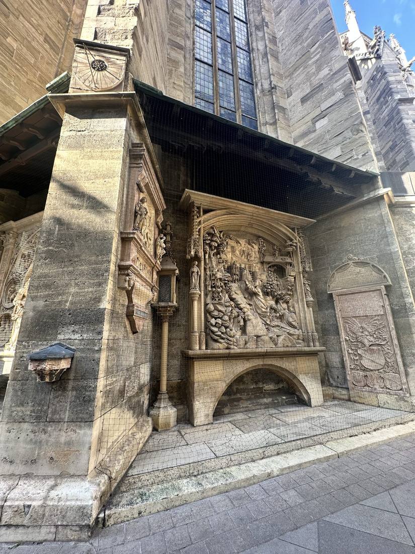 Carved Gothic relief panel and sundial buttress at Stephansdom