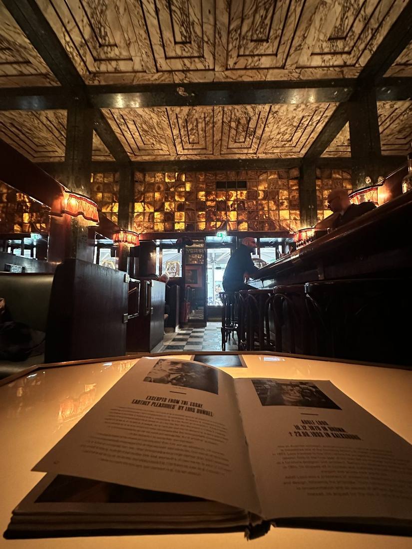 Interior of Loos American Bar with mahogany booths and backlit onyx wall